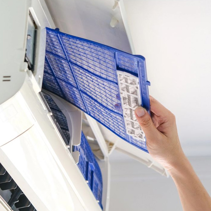 Man checking and fixing AC filter